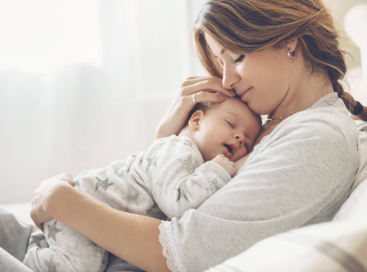 Glückliche junge Mutter mit dem Baby